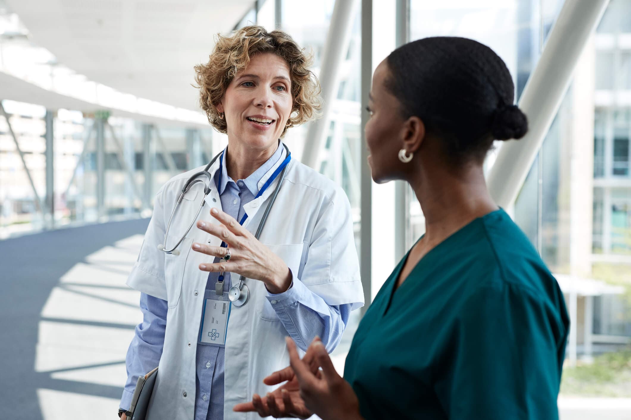 Smiling doctor communicating with colleague on elevated walkway.