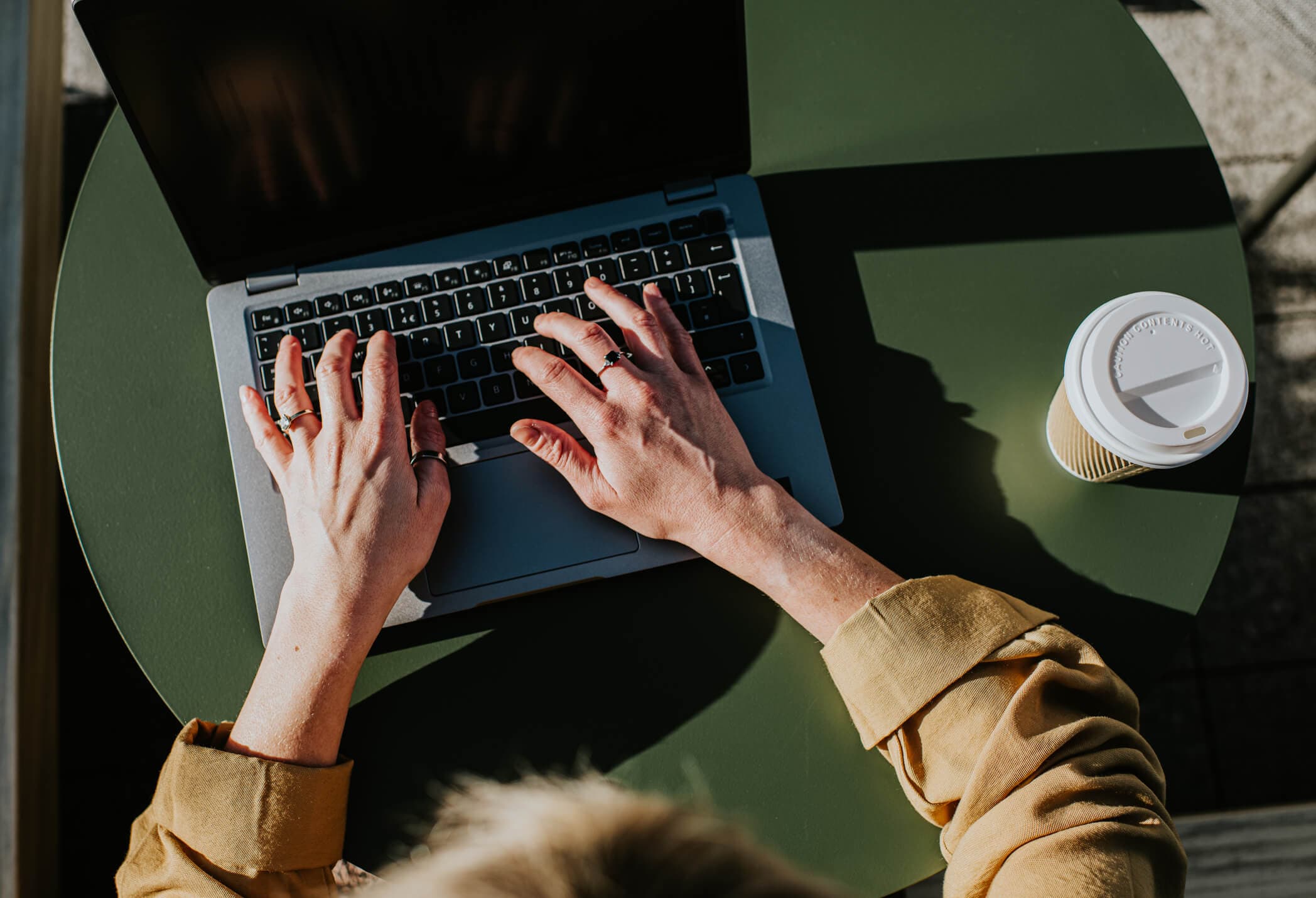 Close-up of hands typing on a laptop computer.