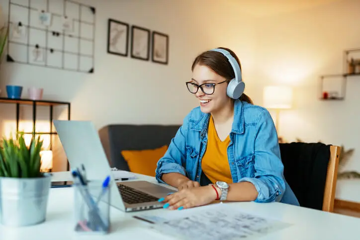 Smiling woman using headphones during online webinar or video call.