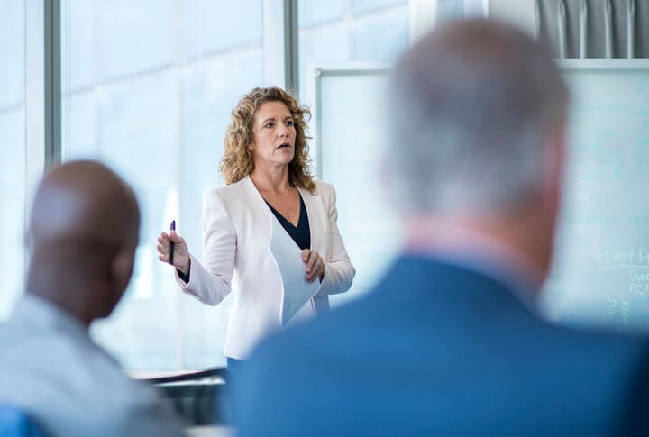 Mature female professional giving presentation at the office.