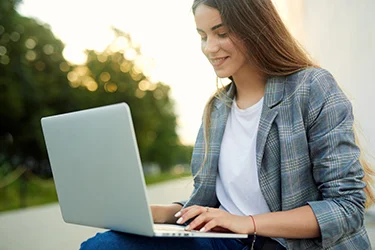 Woman looking down at laptop and smiling slightly