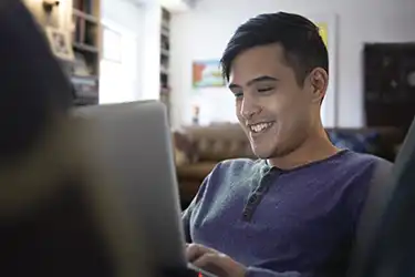 Man sitting at laptop smiling